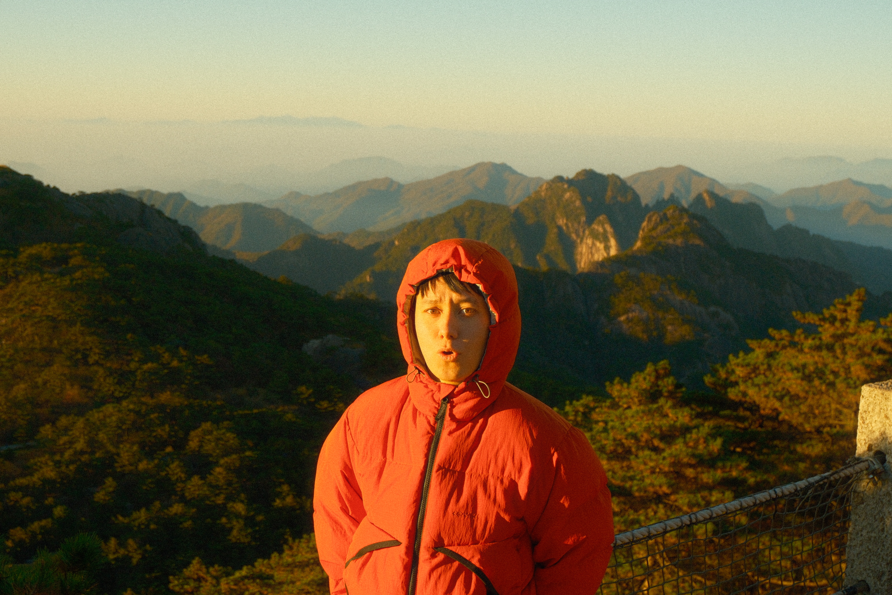 John at sunrise in the Huangshan Mountains, wearing an orange puffer jacket